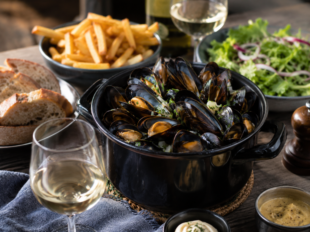 Repas gourmet avec moules, frites, pain et salade